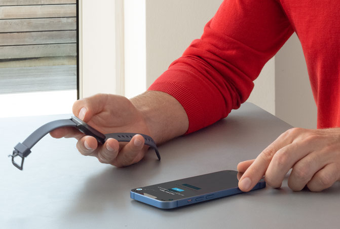 Das Handy liegt am Tisch und wird mit der Smartwatch verbunden.